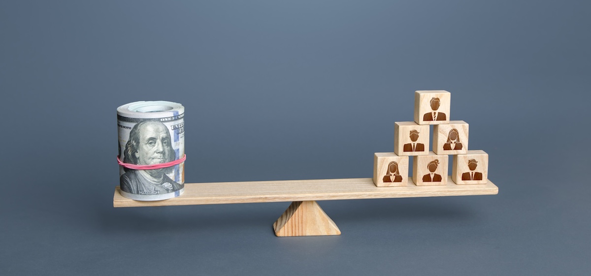 Money and people on a scale, illustrating the true cost of a bad hire