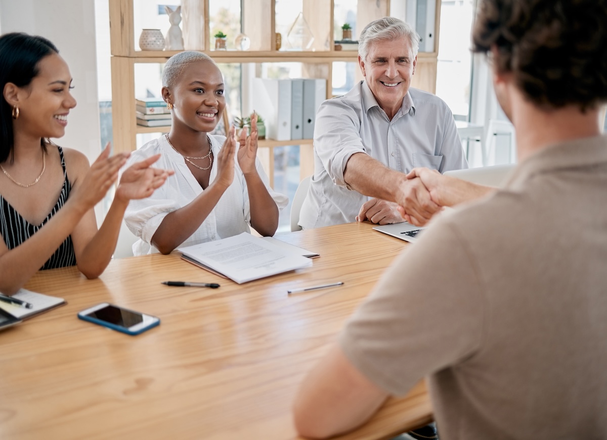 A team welcoming a new hire with a handshake